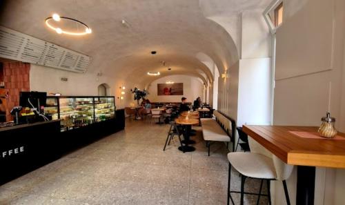 科希策Luxury Vincents Apartments Kosice的餐厅设有长长的走廊,配有桌椅