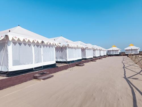 DhordoRann Heritage Resort的海滩上一排白色帐篷