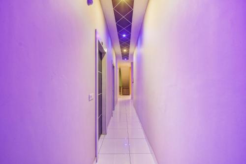 KurukshetraOYO Hotel Sarovar的走廊设有紫色墙壁和瓷砖地板