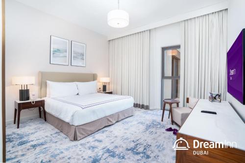 富查伊拉Dream Inn - Address Beach Residence - Luxury Apartments的配有一张床和一张书桌的酒店客房