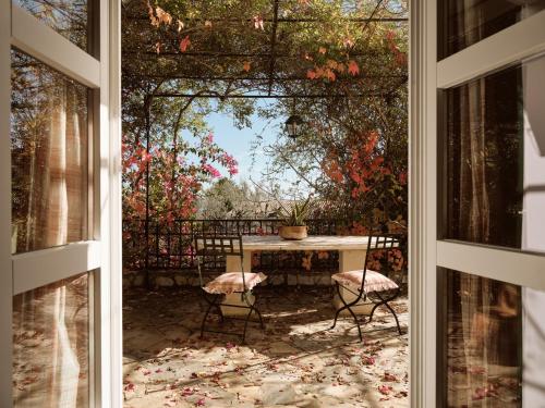 扎金索斯镇Almeira 4acre Estate, for Unparalleled Seclusion, By ThinkVilla的从窗口可欣赏到桌椅的景色