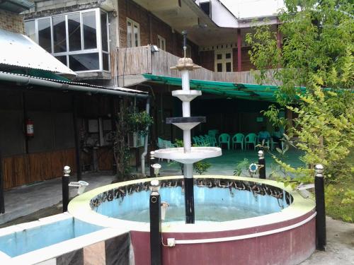 焦尔哈德Ashrayaa Prakreeti.的喷泉位于带游泳池的大楼前