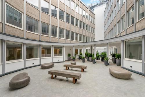 珀利Stunning 1 Bed Studio Flat With FREE PARKING and FREE WIFI in Capella Court Purley的长椅和植物的建筑的庭院