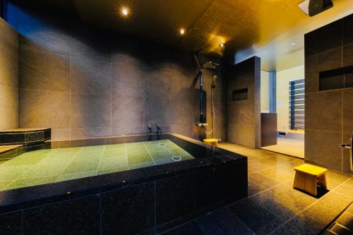 白马村Hakuba Amber Resort by Jade Group的大型浴室设有带淋浴的浴缸。