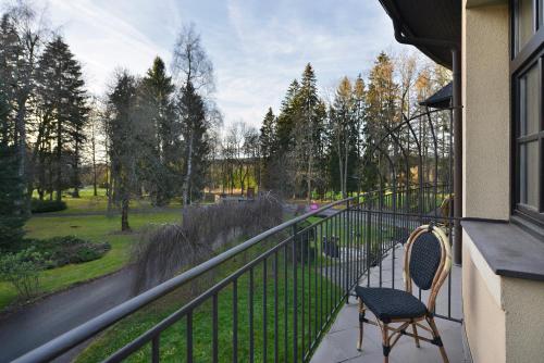 玛丽亚温泉Hotel Morris Relax & Wellness的阳台配有两把椅子,享有公园的景致。