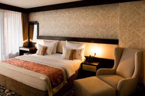 萨拉热窝马拉克丽景湾酒店的配有一张床和一把椅子的酒店客房