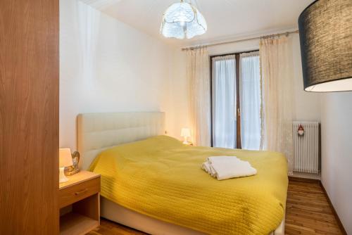 斯皮亚佐Casa D'ala Paiona的一间卧室设有黄色的床和窗户。