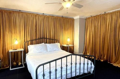 华盛顿Large studio apartment steps from the US Capitol!的一间卧室配有一张带窗帘的床和两盏灯。