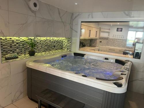 奥尔德伯里Mara Boutique Apartments 1的设有带大浴缸的浴室和大窗户