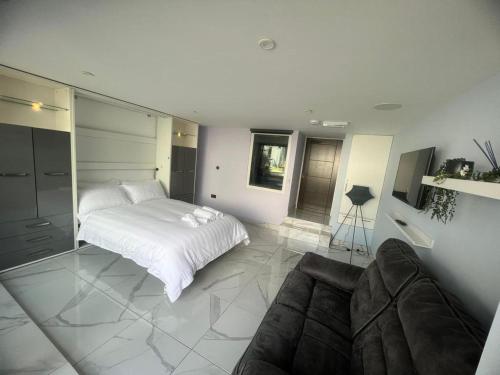 奥尔德伯里Mara Boutique Apartments 1的白色卧室配有床和沙发