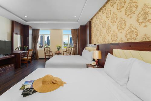 岘港NATURE Hotel By K D H的酒店客房,配有两张床,床上有一顶帽子