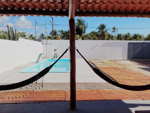 巴拉杜斯科凯鲁斯Casa de Praia Em Aracaju,Se的游泳池前的吊床