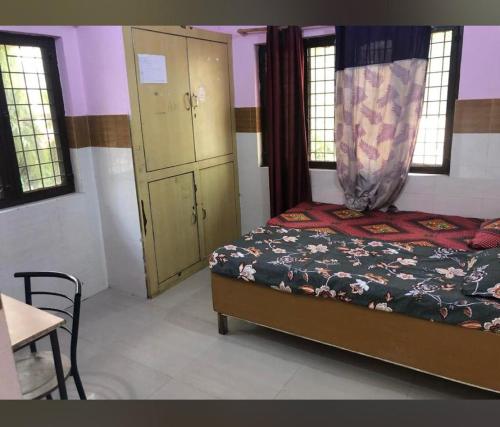 德拉敦Omjee Paying Guest的一间卧室配有一张床、一个橱柜和一张桌子