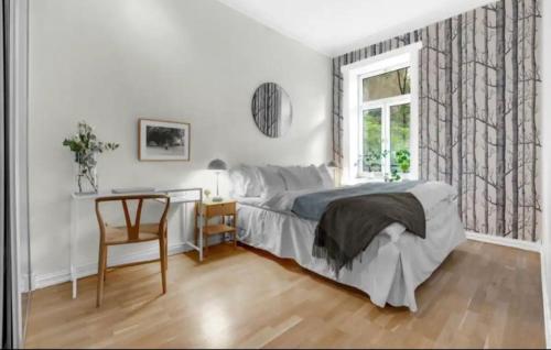 奥斯陆Alexander Kiellands plass - City Center Oslo的一间卧室配有一张床、一张书桌和一个窗户。