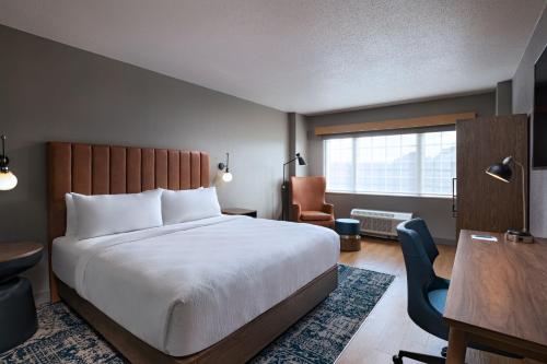 休斯顿西休斯顿喜来登酒店的一间卧室配有一张床、一张桌子和一把椅子
