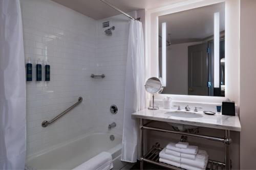 休斯顿西休斯顿喜来登酒店的白色的浴室设有浴缸和水槽。