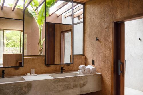圣米格尔-杜斯米拉格里斯Mahré Hotel & Spa的一间带两个盥洗盆和大镜子的浴室