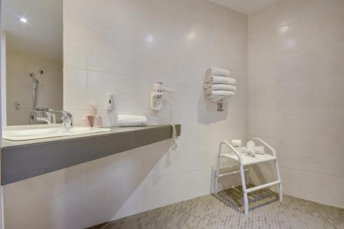 里尔Brit Hotel Lille Centre的浴室配有盥洗盆、镜子和毛巾