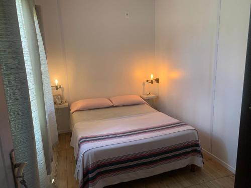 Playa HermosaPIRIA的白色客房内的小床,带两个灯