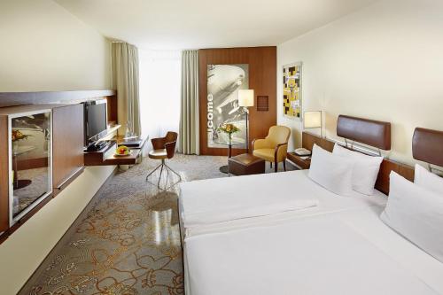 美因河畔法兰克福Essential by Dorint Frankfurt-Niederrad的酒店客房设有一张白色大床和一台电视。