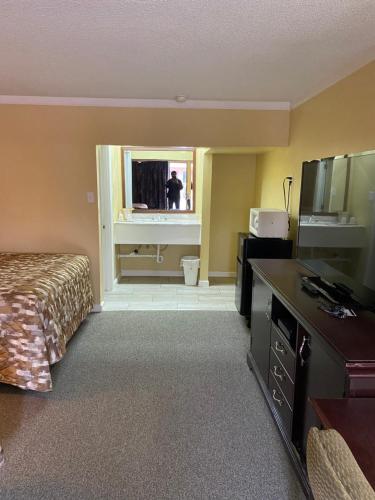 中心城市卡罗诺达汽车旅馆的酒店客房,配有一张床,镜子里的人