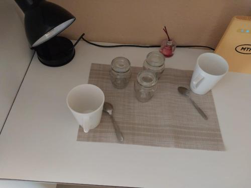 NgodiniThe Grace quest house的一张桌子,上面有三个杯子和勺子,还有一个盒子