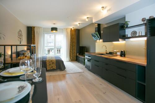 塔林Das Appartement Tallinn的厨房以及带床和桌子的客厅。