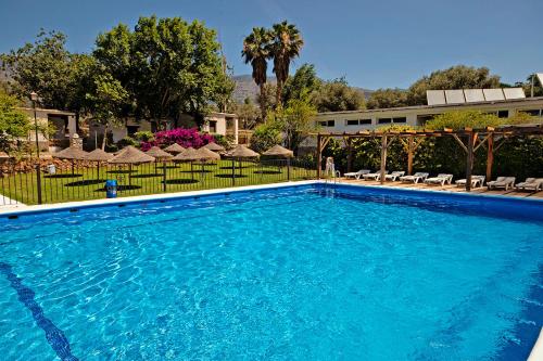 奥尔希瓦奥吉瓦露营酒店的一座带遮阳伞的大型蓝色游泳池和一座建筑