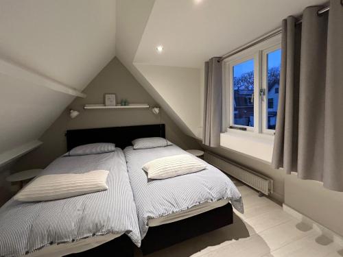 卑尔根Appelbloesem的一间卧室配有一张带白色床单的床和一扇窗户。