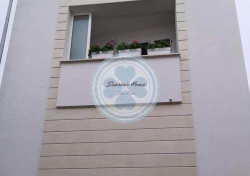 新福卡Seasons Home San Foca的建筑一侧的标志,带有窗户