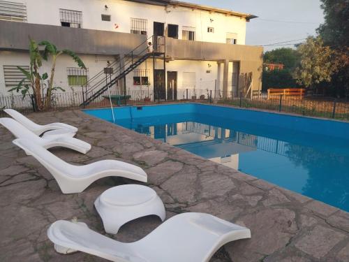 Del VisoComplejo Martin’s的一组白色椅子,位于游泳池旁