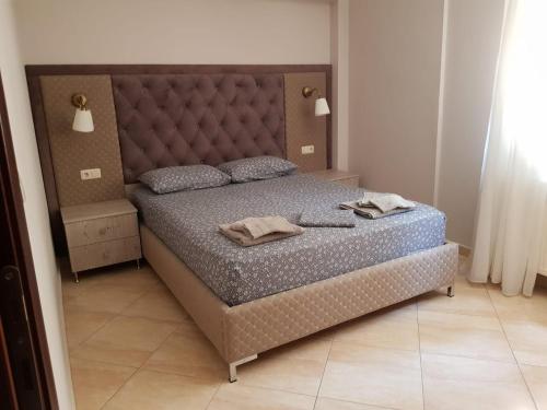 克里皮吉Kriopigi Apartments的一间卧室配有一张大床和大床头板
