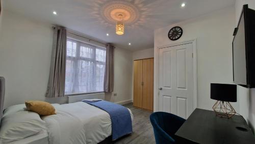 WansteadElegant 2-Bedroom Double En-Suite Flat - London的一间卧室设有一张床,天花板上设有时钟