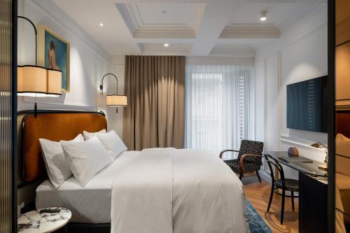 卢布尔雅那AS Boutique Hotel, superior的一间酒店客房,配有一张白色的床和一张书桌