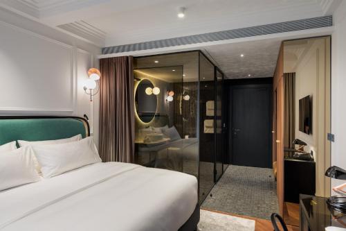 卢布尔雅那AS Boutique Hotel, superior的一间带白色床的卧室和一间浴室