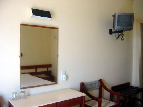 爱琴娜岛Hotel Avra的一间设有镜子、一张桌子和一台电视的房间