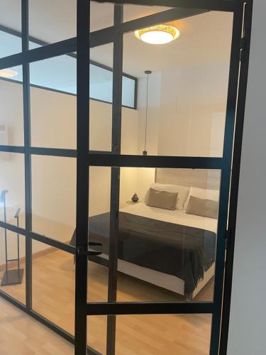 阿尔考本达斯Soho Moraleja I的卧室设有一张透过玻璃窗的床