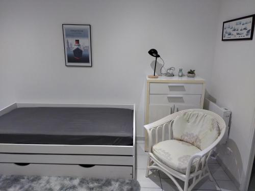 勒阿弗尔charmant studio canapé lit Netflix prime vidéo wifi的一间卧室配有一张床、一把椅子和一个梳妆台