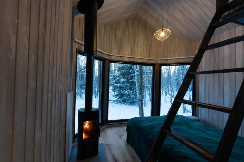 ArduPaunküla Nature Resort (forest villa)的树屋的卧室,配有一张床和壁炉