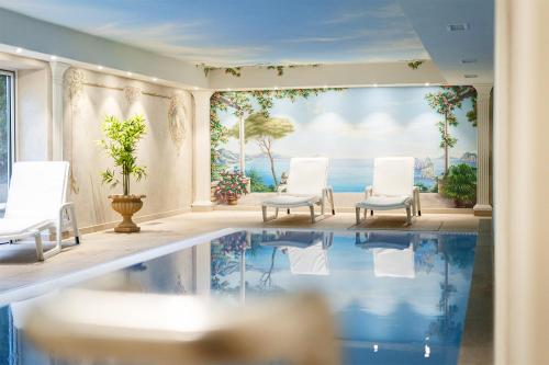 柏林Bernstein Hotel Villa Kastania的海景泳池间 - 带白色椅子