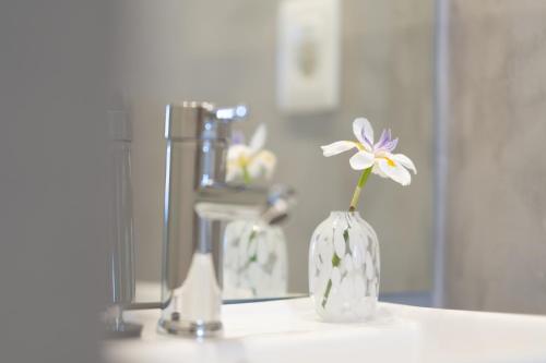 埃斯特角城Vitaminas - Casa de Playa y Café的浴室内花瓶里的花