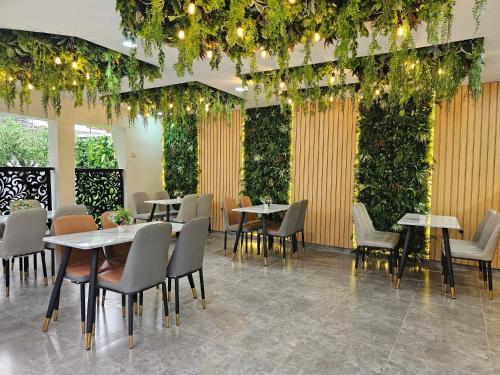 拉各斯Extreme Royal Hotel and Suites的一间设有桌椅的餐厅,种植了植物