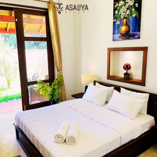 AswalapitiyaAsaliya Villa的一间卧室配有一张床,上面有两条毛巾