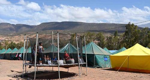 阿加迪尔خيام للكراء ومكان رائع的一群人坐在帐篷前的床上