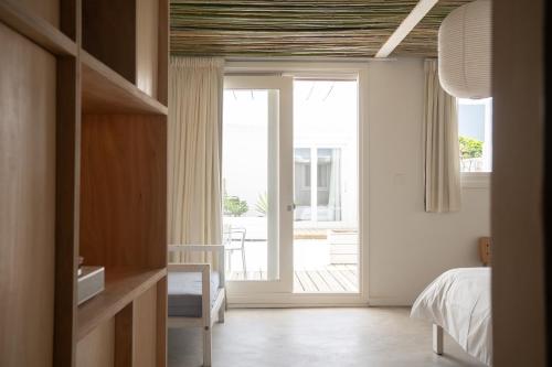 埃斯特角城Vitaminas - Casa de Playa y Café的一间卧室设有一张床和一个滑动玻璃门