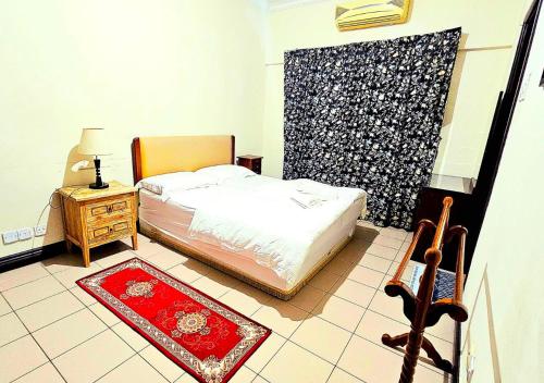 哥打京那巴鲁Ber-Santai at Marina Court的一间卧室配有一张床和一张红色地毯的桌子