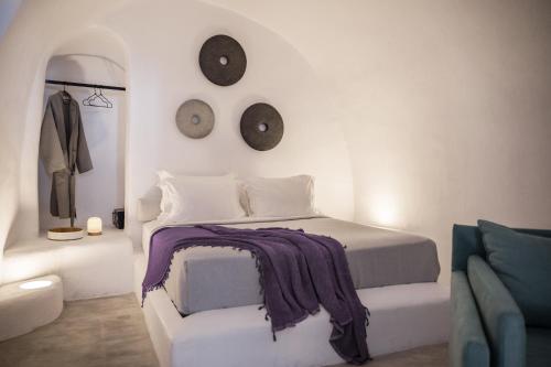 梅加洛克里Yposkafon Concept Villa的一间卧室配有一张床,墙上挂着两个钟。
