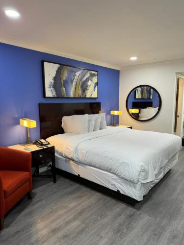 里弗赛德Sands Motel的一间卧室设有一张大床和蓝色的墙壁