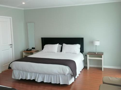 孔斯蒂图西翁德尔里奥酒店的一间卧室配有一张大床和黑色床头板
