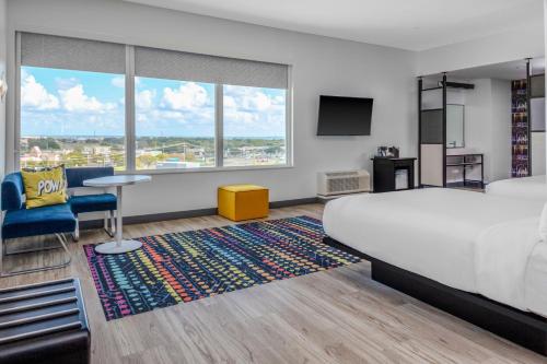 阿林顿Aloft Dallas Arlington South的酒店客房设有一张床、一张书桌和一台电视机。